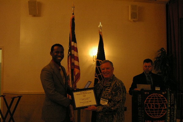 Capt. Gerry Slevin, USN, newly elected chapter president, presents a $2,500 AFCEA War Veterans Scholarship in February to Omar Alexander Reid.